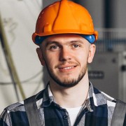 Man with dark facial hair wearing a hard hat